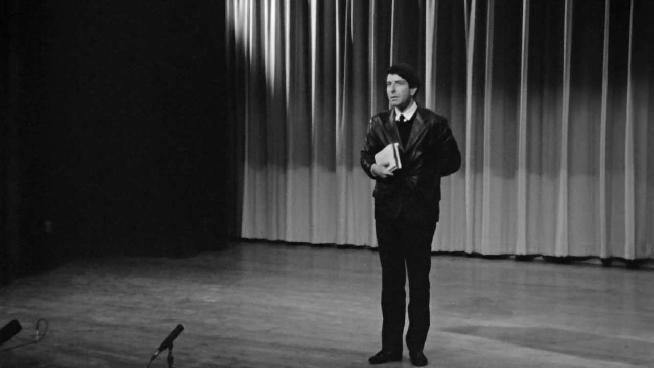 Leonard Cohen on stage in a leather blazer